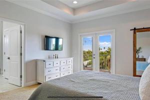 a bedroom with a bed and a dresser with a television at Luxurious Modern Townhouse right across beach!! Table Tennis in St Pete Beach