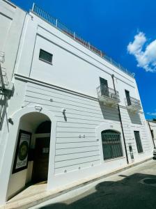 een wit gebouw met een boog ervoor bij Novecento Room and Breakfast Puglia in Massafra
