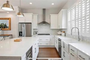 a white kitchen with white cabinets and a sink at Luxurious Modern Townhouse right across beach!! Table Tennis in St Pete Beach