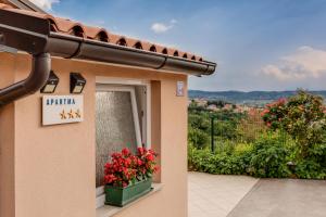 a building with a window with flowers on it at Casa Badiha in Zgornje Škofije