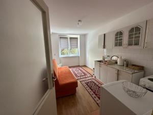 uma pequena cozinha com uma cadeira laranja num quarto em Apartman Mina em Sarajevo