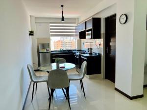 a kitchen and dining room with a table and chairs at Acogedor departamento en el corazón de cochabamba in Cochabamba