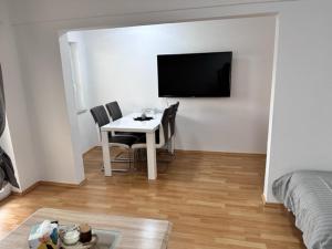 a living room with a table and a tv on a wall at M&L Wohnen 2 in Essen +10 photos