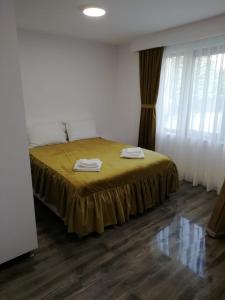 a bedroom with a bed with a yellow bedspread at STUDIO 25 in Vaslui