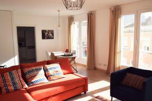 uma sala de estar com um sofá laranja e uma mesa em Barbadinhos Apartment em Lisboa
