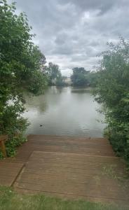 vistas a un lago con muelle de madera en Anglers Rest, with Hot Tub and Private Fishing Peg, en Tattershall