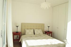 a white bedroom with a bed and two night stands at Barbadinhos Apartment in Lisbon