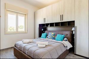 a bedroom with a large bed with blue pillows at Il Casello Country House in Sciacca