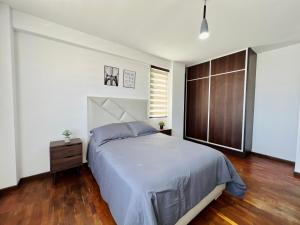a bedroom with a large bed and a window at Acogedor departamento en el corazón de cochabamba in Cochabamba