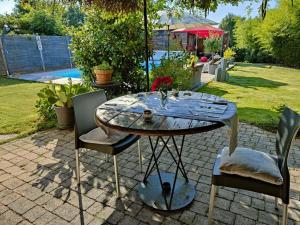 une table et des chaises assises sur une terrasse dans l'établissement La maison du Lac, à Éguzon-Chantôme