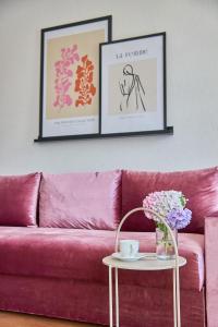 um sofá rosa numa sala de estar com duas fotografias emolduradas em Best Apartments on Kyryla & Mefodia em Mukacheve