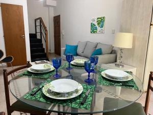 a glass table with plates and blue glasses on it at Duplex 2 dormitorios con cochera en Banfield in Banfield