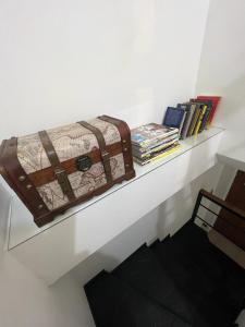 una valigetta seduta su uno scaffale con dei libri di Duplex 2 dormitorios con cochera en Banfield a Banfield