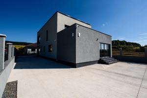 Livezeni的住宿－Concept Villa，黑色和白色的房子,有车道