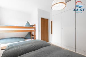 a bedroom with a bunk bed with blue pillows at Haus Hamburg 181 Wohnung 1 in Juist