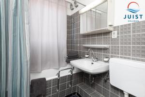 a bathroom with a sink and a toilet and a shower at Haus Hamburg 181 Wohnung 1 in Juist +10 photos