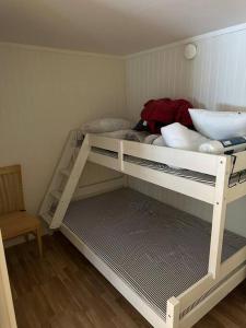 a white bunk bed in a room with a chair at Apartment in Lindvallen in Sälen