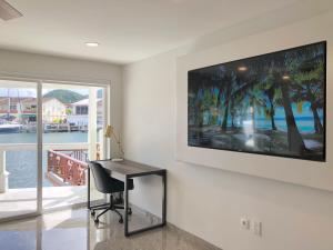 a desk in a room with a television on a wall at 230A South Finger in Jolly Harbour