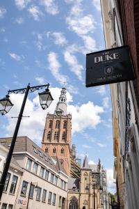 un cartel en un edificio con una torre de reloj en The Duke Boutique Hotel en Den Bosch