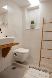 y baño con aseo blanco y lavamanos. en Secret Khora en Mykonos ciudad