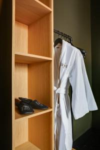 a white robe is hanging on a shelf at The Duke Boutique Hotel in Den Bosch