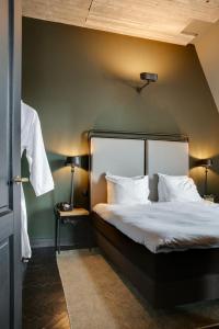 ein Schlafzimmer mit einem Bett mit einer grünen Wand in der Unterkunft The Duke Boutique Hotel in ’s-Hertogenbosch