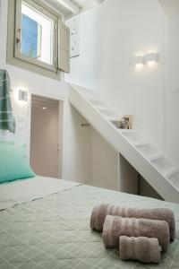 a bedroom with a staircase and two towels on the floor at Mykonos Alley Stars - Secret Khora - 360 View in Mýkonos City