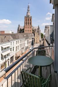 a balcony with a table and chairs and a view of a city at The Duke Boutique Hotel in Den Bosch