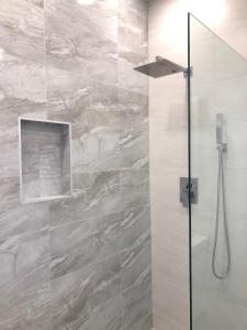 a bathroom with a shower with a stone wall at 232C South Finger in Jolly Harbour