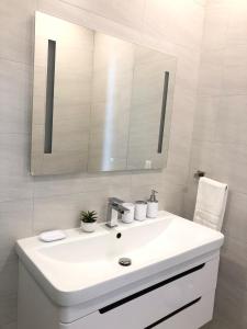 a white bathroom with a sink and a mirror at 232C South Finger in Jolly Harbour