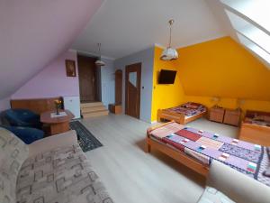 sala de estar con cama y pared amarilla en Dom Gościnny u Szymona en Wrzosowo