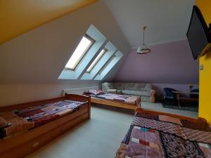 Zimmer im Dachgeschoss mit 2 Betten und einem Sofa in der Unterkunft Dom Gościnny u Szymona in Wrzosowo