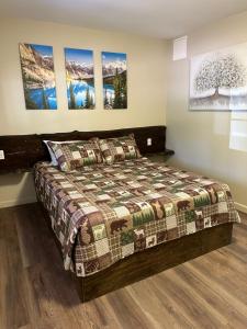 a bedroom with a bed and paintings on the wall at Crater Lake Gateway - Hwy 140 in Klamath Falls