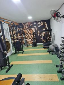 einen Fitnessraum mit einem Gemälde an der Wand in der Unterkunft Condomínio mais Maracanã B1 AP 708 in Rio de Janeiro