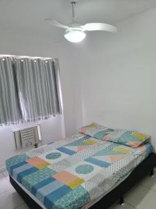 ein Schlafzimmer mit einem Bett mit einer bunten Bettdecke in der Unterkunft Condomínio mais Maracanã B1 AP 708 in Rio de Janeiro