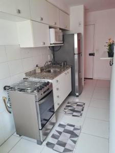 a kitchen with a stove and a sink at Condomínio mais Maracanã B1 AP 708 in Rio de Janeiro