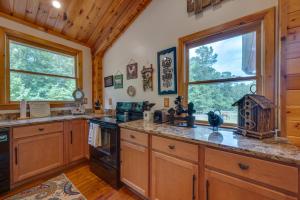 a large kitchen with wooden cabinets and windows at Pet-Friendly Dry Branch Ranch Vacation Rental! 