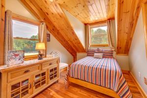 a bedroom in a log cabin with a bed and windows at Pet-Friendly Dry Branch Ranch Vacation Rental! 
