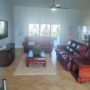 ein Wohnzimmer mit einem Ledersofa und einem Tisch in der Unterkunft Areca Palms Cape Coral with HEATED POOL in Cape Coral