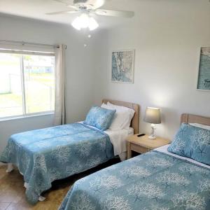 1 Schlafzimmer mit 2 Betten und einem Deckenventilator in der Unterkunft Areca Palms Cape Coral with HEATED POOL in Cape Coral