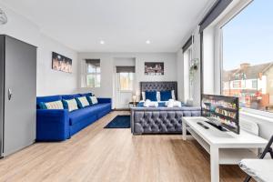 a living room with a blue couch and a table at Sydenham Stays by Hayes Residency in London