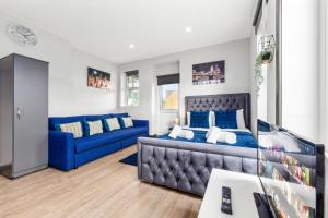 a living room with a blue bed and a blue couch at Sydenham Stays by Hayes Residency in London