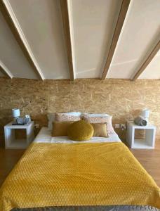 a bedroom with a large yellow bed with two night stands at Arrendar braga in Braga