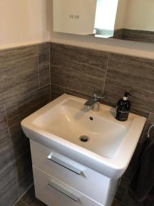 a white sink in a bathroom with a mirror at Woodcliff in Birkenhead