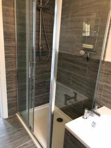 ein Bad mit einer Dusche und einem Waschbecken in der Unterkunft Woodcliff in Birkenhead