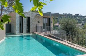 a swimming pool in front of a house at Villa KEY WEST & Unique & Piscine & Vue Mer & Clim in Mougins
