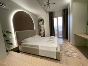 a bedroom with a bed and a large window at Deluxe Residence in Durrës