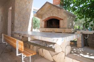 a stone pizza oven with a bench next to it at Bepo in Zadar