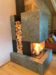 a fireplace in a room with a pile of wood at Löberbauer, Ferienwohnung in Tux