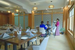 a dining room with people sitting at tables at Cholay Khangzang in Thimphu